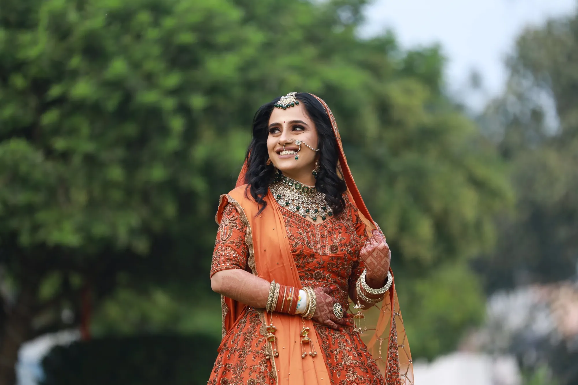 Smiling bride in an orange lehenga