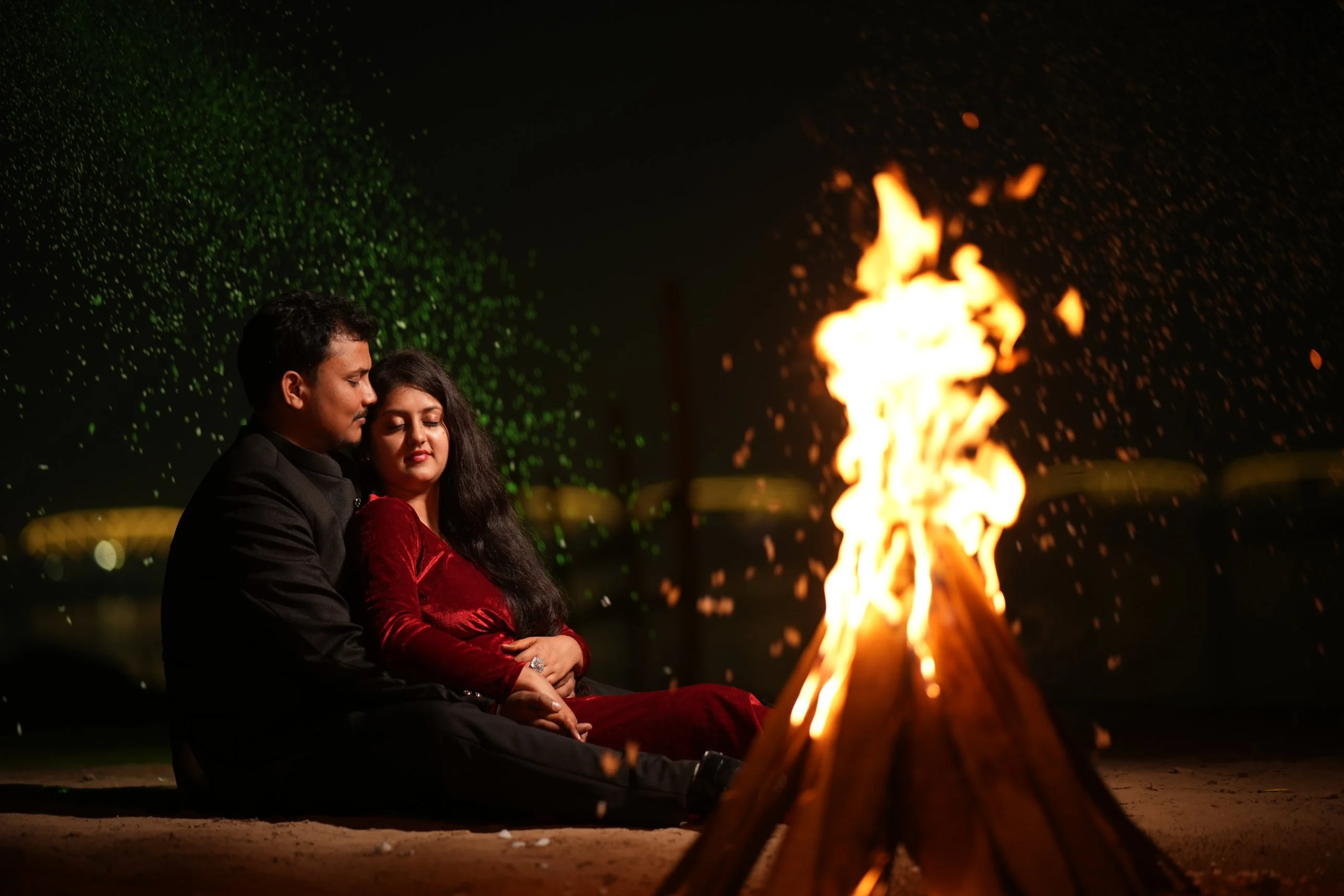 Couple by a bonfire at night, bride in red velvet